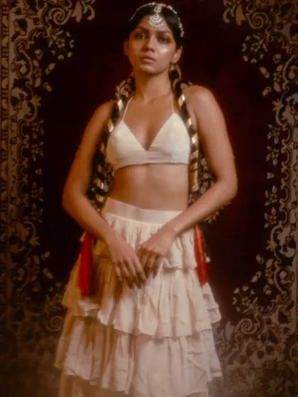 A direct, centered portrait from the 'Lila' shoot. This image clearly shows the complete outfit, from the layered skirt to the unique hair styling, capturing the essence of modern heritage.