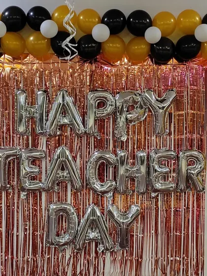 A close-up of the "Happy Teacher Day" foil letters against the shimmering backdrop.
