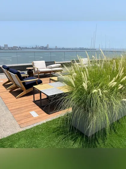 A seating nook on a Mumbai rooftop, positioned to offer breathtaking views of the sea. I used tall ornamental grasses in a modern planter to create a sense of enclosure and a soft, natural texture against the urban skyline.