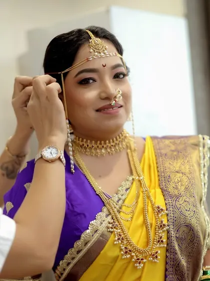 A candid moment of me adjusting the bride's traditional mundavalya. I ensure every single detail is perfect.