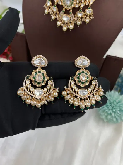 This collection showcases our premium Moissanite Kundan necklaces like the 'Noor Nazaakat' and 'Darbaar' sets. Each comes with a full set of earrings and maang tikka, available in various color combinations.