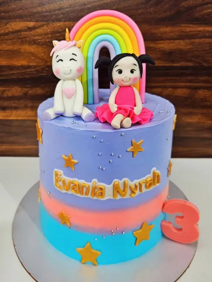 A sweet unicorn and rainbow cake for Evania's 3rd birthday. This vanilla cake with white chocolate mousse has a lovely pastel color palette and cute, handcrafted toppers.