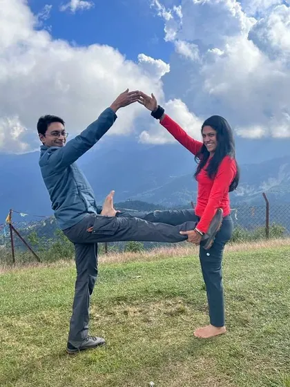 A creative partner pose forming a house shape. Yoga can be playful, and practicing with a partner in nature adds an element of fun and creativity to the journey.