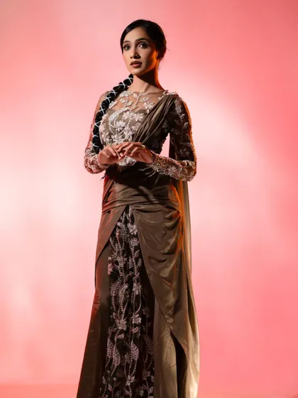 The full look of the custom fusion saree-gown. The way the satin drapes over the embroidered underskirt creates a unique and modern red carpet outfit that stands out from a traditional saree or gown.