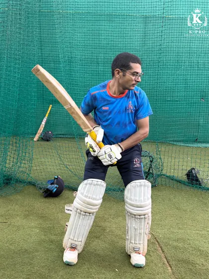 A player holds his pose after playing a shot in the indoor nets, a sign of good balance and a complete follow-through.