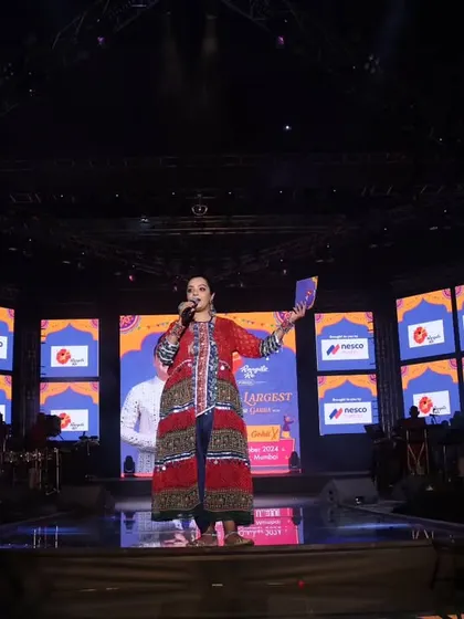 A powerful shot of me addressing the audience from the center of the grand stage. This demonstrates my confidence and ability to be the central anchor for major productions.