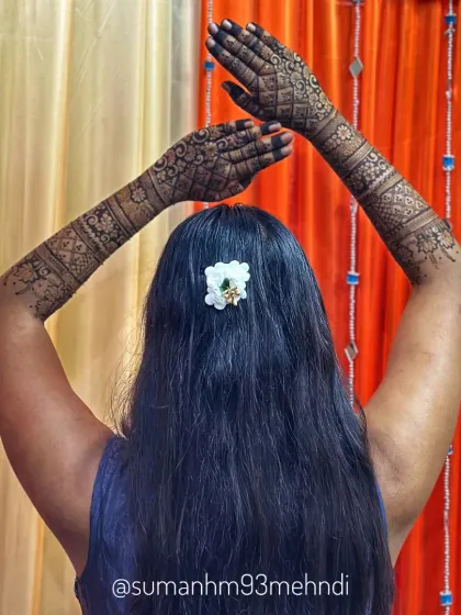 A beautiful back view displaying the symmetry and detail of the henna design on both arms. The pattern flows seamlessly, creating an elegant and complete bridal look.