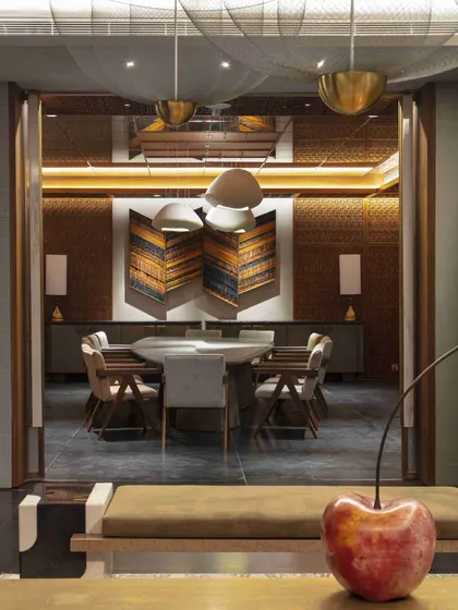 A playful cherry sculpture sits in the foreground, with a view into the stunning basement dining room. This composition showcases our love for unexpected, whimsical details within a sophisticated design.