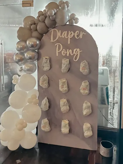 Add some fun to your baby shower with a "Diaper Pong" game station. I create a custom board and decorate it with matching balloons to fit your party's theme.