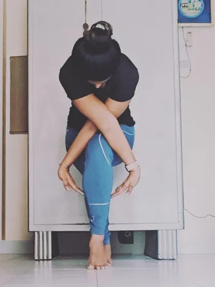 This is 'Infinity Eagle Pose', a creative variation of chair pose that challenges wrist extension and balance. It's a beautiful shape that requires focus and stability.