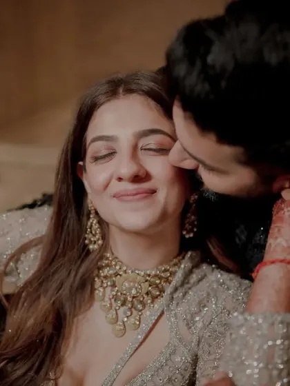 A tender moment captured in a warm, low-light setting, showcasing the couple's gentle affection.