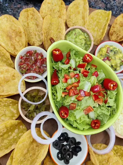 Get the party started with our vibrant Taco Platter. It comes with everything you need: crispy taco shells, fresh lettuce, salsa, guacamole, mango salsa, refried beans, and assorted toppings for a build-your-own taco experience.