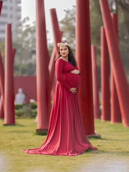 A striking solo portrait in a red gown, set against a modern backdrop of red pillars.