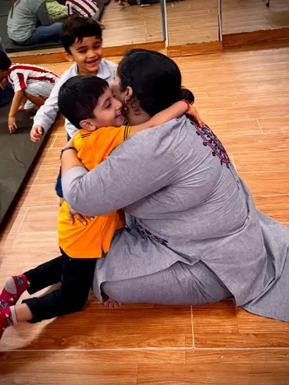 The smiles say it all. A child's happy embrace shows the joyful and positive atmosphere that makes kids excited to come to our classes.
