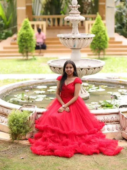 Our client posing by a fountain in her custom red gown. It was the perfect outfit for her romantic pre-wedding shoot.