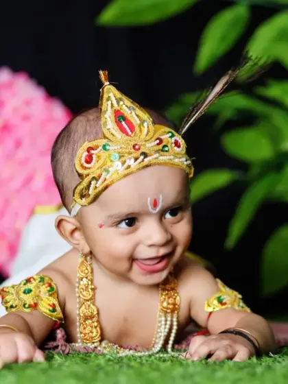 Another delightful portrait from our Janmashtami series, this photo captures a smiling baby boy dressed as Krishna, showcasing his cheerful personality against our festive studio setup.