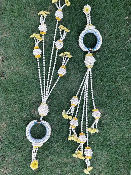 A pair of handcrafted floral hathphool with kalire. The design uses mogra buds and yellow flowers, perfect for matching with a yellow Haldi outfit.