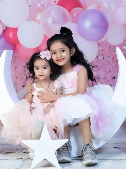 Sisterly love on our moon and stars set. This setup is perfect for sibling photoshoots, especially for birthdays or special milestones. The pastel balloons add a celebratory touch.