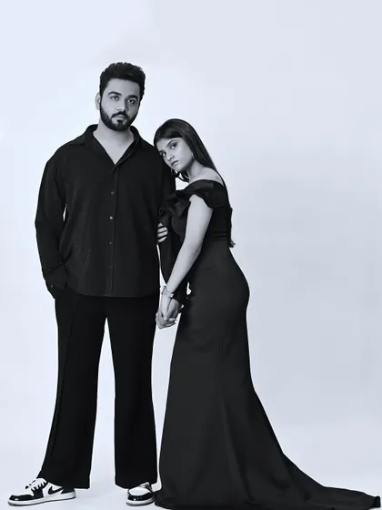 A modern and stylish black and white couple portrait taken in my studio. The clean background and classic posing highlight the couple's connection and individual style, showcasing a timeless yet contemporary look.