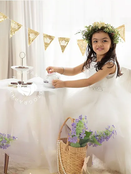 Pouring tea for her teddy bear guest. These play-based sessions are perfect for capturing a toddler's natural expressions and imagination.