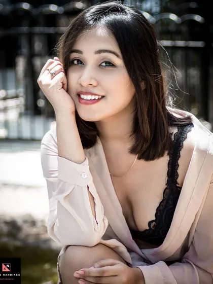 A bright and happy outdoor portrait. The model's genuine smile and the soft, natural light create a warm and engaging image that feels candid and full of life.