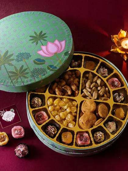 The Shubh Dipawali hamper offers a perfect balance of sweet and savory, with meethi mathri, kaju oregano parrey, golden berries, and assorted sugar-free mithai.