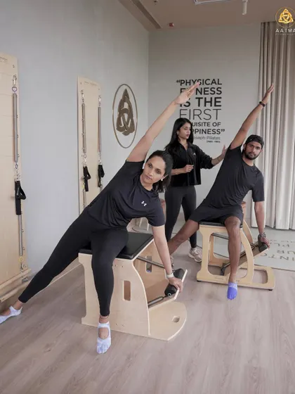 A side stretch on the Wunda Chair, performed in a duet session. I'm there to guide and correct, helping both clients achieve a deeper stretch and better alignment.