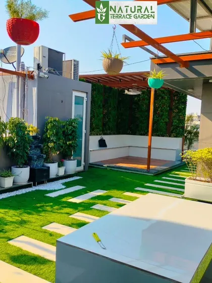 A sunny shot of the Sonipat terrace, with colorful hanging planters adding a playful touch to the modern design.