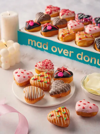 A box of assorted heart-shaped donuts from Mad Over Donuts. This shot is perfect for seasonal promotions like Valentine's Day, showcasing the variety and festive nature of the product.