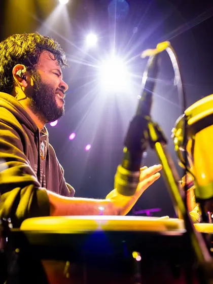 Lost in the music under the stage lights. This close-up shows me playing the congas, a core part of my world percussion setup for live fusion and rock bands.