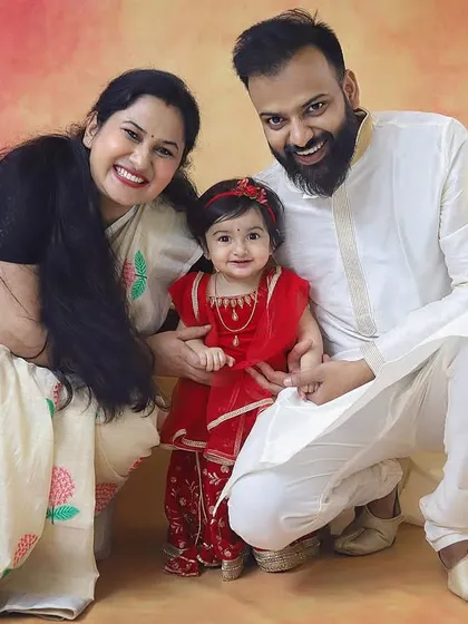 A happy family celebrating Janmashtami together. Their coordinated traditional outfits and big smiles make this such a warm and festive portrait.