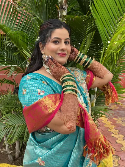 A vibrant engagement look for this bride in a beautiful turquoise saree. The makeup features a pop of color on the lips.