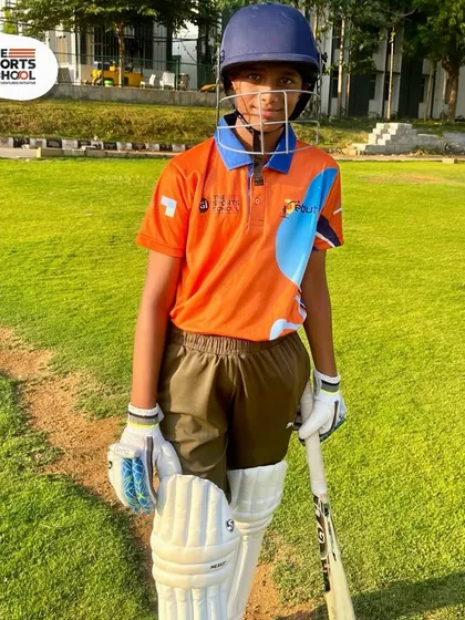 A young batsman poses with his gear on the cricket ground, embodying the passion and excitement of our summer camp participants.
