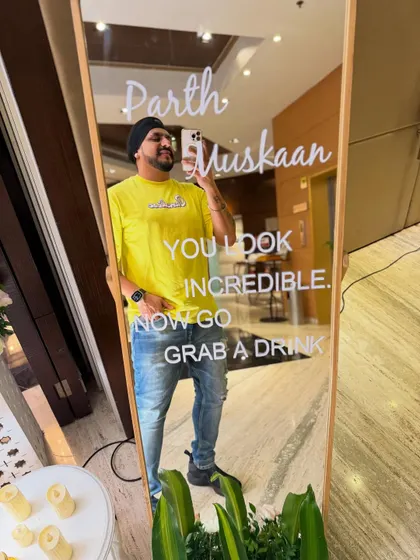 A quick selfie before the party starts. The custom decor, like this fun mirror for the wedding of Parth and Muskaan, adds a personal touch that I love to see at events.