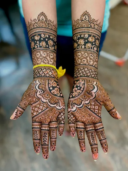 A gorgeous bridal design with bold floral bands on the forearms. The palms feature a classic mandala-style pattern with intricate details.