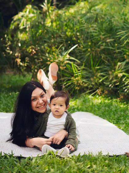 A sweet mother and son moment during a picnic in the park. The relaxed, playful pose captures the easy-going love they share.