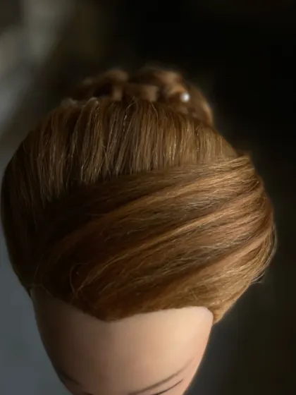 The foundation of an elegant updo. This image shows the smooth, polished base of a bun before the decorative elements are added.