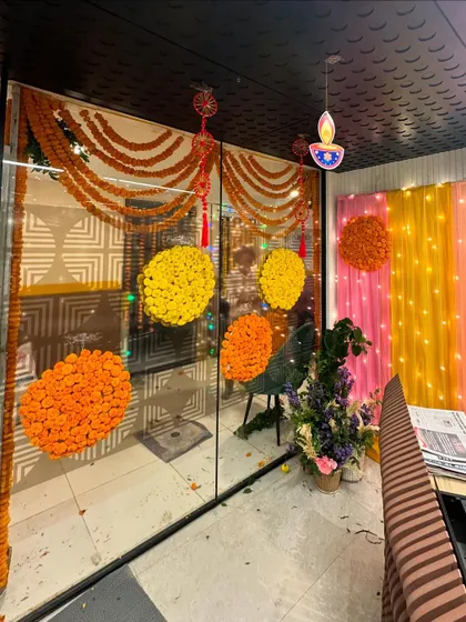 Festive Diwali decor for an office entrance, featuring marigold garlands and a colorful backdrop to welcome employees.