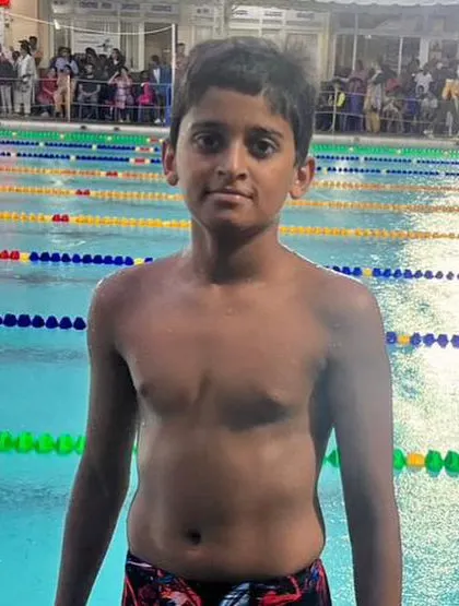 A duplicate image of a proud young swimmer by the pool.
