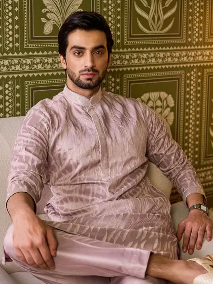 A seated portrait that allows a closer look at the fabric's texture and the rich, understated color of this unique kurta set.