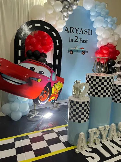 A close-up view of the Lightning McQueen character prop and the checkered flag details in this racing-themed party decoration.