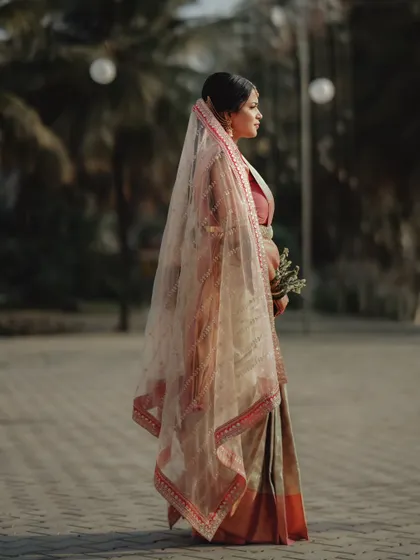 A full-length portrait of a bride in her veil. The soft, even light and her elegant posture create a classic and graceful image.