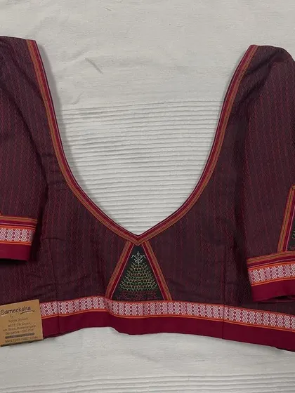 This deep maroon blouse in Ilkal cotton features a deep V-neck and is embellished with traditional 'gopura' motifs using Negi and Kasuti embroidery.