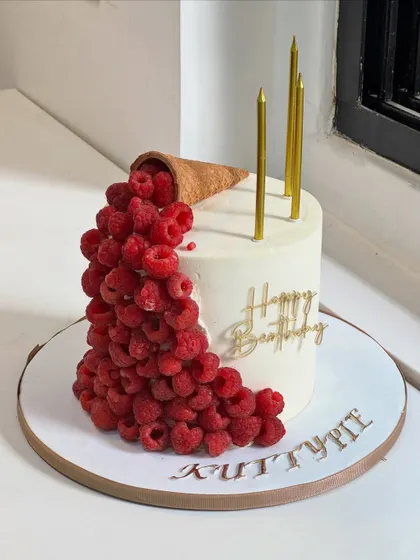 When elegance meets indulgence. This modern cake design features fresh raspberries cascading from a cone, complemented by clean lines and golden details for an unforgettable birthday moment.