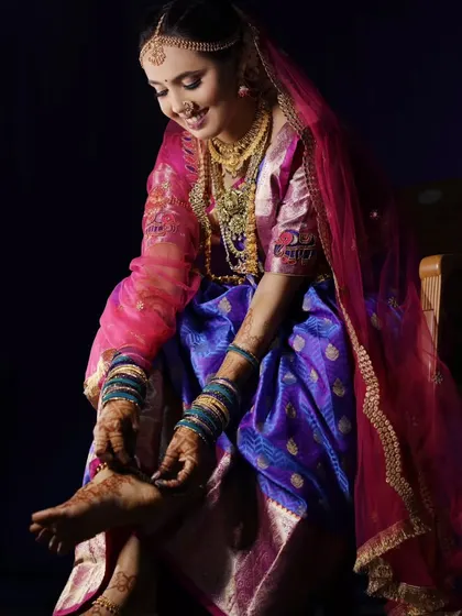 A candid moment of the bride adjusting her toe ring, a beautiful detail shot that captures the traditions of getting ready.