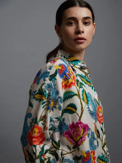 A vibrant and colorful portrait for a fashion collection. The detailed floral print is the hero of this shot, and the model's expression is both soft and engaging.