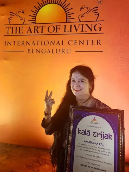 A victory sign with my 'Kala Srijak' award at the Art of Living International Center in Bengaluru.
