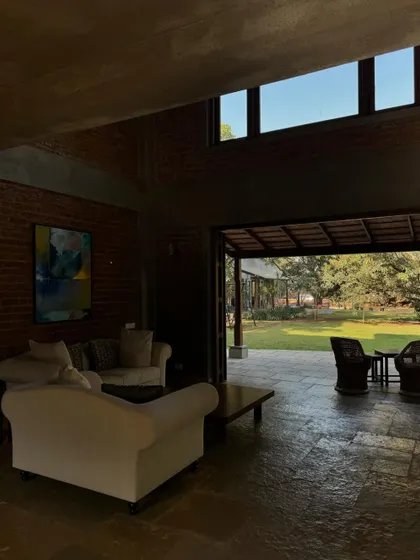 The living room at The Mango House, with its comfortable sofas and view out to the garden. The design is simple and unpretentious, focusing on creating a relaxed and welcoming environment.