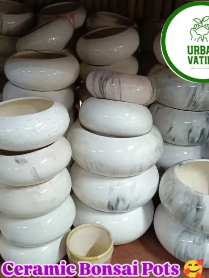 A stack of beautiful ceramic bonsai pots with a marble finish.