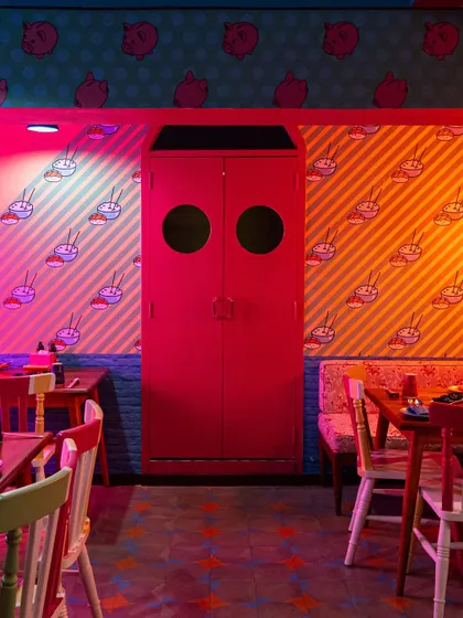 Even a simple door becomes a design feature at The Fatty Bao. The bold color and surrounding graphic wallpaper are captured to show how every part of the interior contributes to the overall theme.